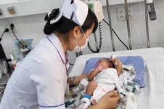 Các bác sỹ Bệnh viện Nhi đồng 2 điều trị tích cực cho bệnh nhi mắc bệnh lý hô hấp. (Ảnh: Đinh Hằng/TTXVN)