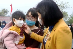 Bà Nguyễn Thị Tuyến, Phó Bí thư Thường trực Thành ủy Hà Nội trao quà cho con công nhân lao động. (Ảnh: TTXVN phát) 