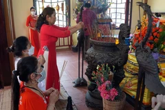 Người dân thắp hương tại mộ phần của Bà Thu Bồn trong khuôn viên lễ hội. (Ảnh: Trịnh Bang Nhiệm/TTXVN) 