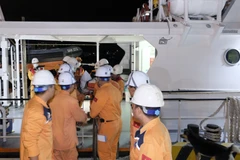 Lực lượng cứu hộ tàu SAR 272 sơ cấp cứu ban đầu cho bệnh nhân và thực hiện tiếp nhận, sau đó hướng tàu vào đất liền. (Ảnh Đặng Tuấn/TTXVN)