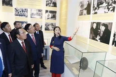 Phó Thủ tướng Thường trực Phạm Bình Minh và Thường trực Ban Bí thư, Phó Chủ tịch nước Lào Bounthong Chitmany cùng các đại biểu tham quan triển lãm. (Ảnh: An Đăng/TTXVN)