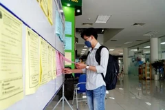 Người lao động tìm hiểu công việc tại phiên giao dịch việc làm. (Ảnh: TTXVN)