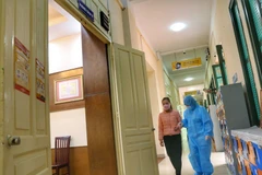 Đưa học sinh có thân nhiệt cao vào phòng cách ly. (Ảnh: Tuấn Đức/TTXVN) 