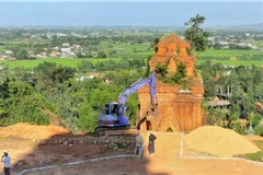 Nhà thầu thi công đưa máy đào vào thi công tại Di tích Tháp Bánh Ít. (Ảnh: TTXVN phát)