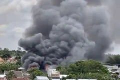 Vụ hỏa hoạn tạo thành cột khói cao hàng chục mét nhìn từ xa. (Ảnh: TTXVN phát)