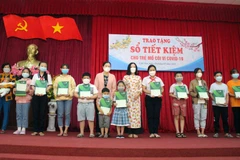 Trao sổ tiết kiệm cho trẻ em mồ côi do ảnh hưởng COVID-19 trên địa bàn thành phố Cần Thơ. (Ảnh: Trung Kiên/TTXVN)