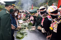 Bộ đội Biên phòng cùng với bà con nhân dân xã Huổi Luông, huyện Phong Thổ gói bánh chưng xanh tặng cho hộ nghèo. (Ảnh: Đinh Thùy/TTXVN)