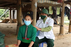 Cán bộ quân y Đồn Biên phòng Mường Cai, Bộ Chỉ huy Bộ đội Biên phòng Sơn La khám bệnh cho người dân vùng biên huyện Sông Mã. (Ảnh: Hữu Quyết/TTXVN)