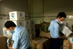 Quản lý thị trường kiểm đếm số lượng lớn hàng lậu. (Ảnh: Thành Chung/TTXVN)