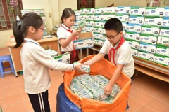 Học sinh thu gom vỏ hộp sữa. (Ảnh: PV)