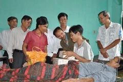 Ủy ban Mặt trận Tổ quốc Việt Nam tỉnh Quảng Ngãi trao tặng quà cho hai cha con ông Hồ Văn Thanh và Hồ Văn Lang. (Ảnh: Thanh Long/TTXVN)