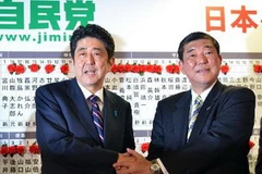 Cựu Thủ tướng Shinzo Abe (trái) và Tổng thư ký Shigeru Ishiba trong buổi niêm yết tên cử tri trong cuộc bầu cử Hạ viện ở Tokyo ngày 16/12. (Ảnh: AFP)
