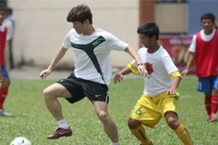 Park Ji-Sung hướng dẫn trẻ em Việt Nam chơi bóng. (Ảnh: Quang Nhựt/TTXVN)