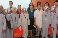 Các bác sĩ Việt Nam và Singapore cùng một số bệnh nhân vừa được mổ mắt. (Ảnh: H.Minh/Vietnam+)