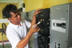 Thượng úy Nguyễn Như Trúc đang tiến hành vệ sinh máy móc trạm thông tin và năng lượng ở trên đảo Sinh Tồn Đông. (Ảnh: Đỗ Hùng/Vietnam+) 