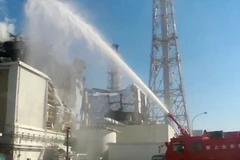 Lính cứu hỏa Nhật Bản phun nước làm nguội lò phản ứng số 3. (Nguồn: AFP/TTXVN)