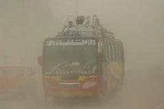 Ôtô đi trong bão bụi ở Peshawar ngày 5/6. (Ảnh: THX/TTXVN)