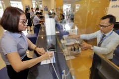 Khách hàng giao dịch tại Ngân hàng Bảo Việt chi nhánh Gia Lai. (Ảnh: Trần Việt/TTXVN)