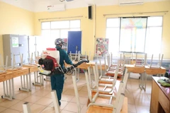 Nhân viên y tế quận Hoàn Kiếm phun thuốc khử trùng các phòng học trường THPT Việt Đức (ảnh chụp chiều 2/2/2020). (Ảnh: Thành Đạt/TTXVN)