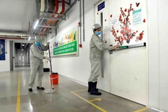 Lau sàn nhà và tay nắm cửa bằng dung dịch sát khuẩn tại Công ty trách nhiệm hữu hạn sản xuất hàng may mặc Việt Nam (TAL), khu công nghiệp Bá Thiện 2 (huyện Bình Xuyên). (Ảnh: Hoàng Hùng/TTXVN)