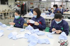 Công nhân Công ty cổ phần đầu tư và thương mại TNG kiểm tra sản phẩm trước khi xuất xưởng. (Ảnh: Hoàng Nguyên/ TTXVN)