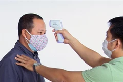 Kiểm tra thân nhiệt hành khách từ Hà Nội đến Phú Yên. (Ảnh: Xuân Triệu/TTXVN)