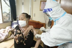 Nhân viên y tế phường Cửa Đông (quận Hoàn Kiếm, Hà Nội) tiêm cho người cao tuổi tại nhà. (Ảnh: Minh Quyết/TTXVN)