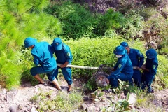 Lực lượng chức năng di chuyển một quả bom tới địa điểm để hủy nổ. (Ảnh: Tá Chuyên/TTXVN)