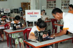 Dạy nghề may cho các nạn nhân chất độc da cam. (Ảnh: Lê Lâm/TTXVN)