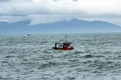 Lực lượng biên phòng tìm kiếm người mất tích trong vụ chìm canô du lịch tại Cửa Đại. (Ảnh: TTXVN)