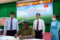 Tổng thống Cộng hòa Sierra Leone Julius Maada Bio viết sổ lưu niệm tại Viện Lúa Đồng bằng sông Cửu Long. (Ảnh: Thanh Liêm/TTXVN)
