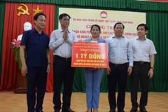 Bí thư Đảng ủy Khối các cơ quan Trung ương, ông Huỳnh Tấn Việt (thứ 2 từ trái) trao bảng tượng trưng 1 tỷ đồng hỗ trợ tỉnh Bình Định xây dựng 20 căn nhà cho hộ nghèo, chính sách. (Ảnh: Kha Phạm/TTXVN)