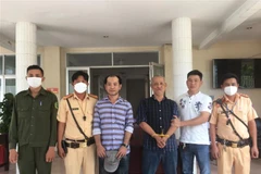 Trạm Cảnh sát giao thông thị xã Trảng Bàng tổ chức bàn giao 2 đối tượng trộm ôtô cho Công an thành phố Tây Ninh. (Ảnh: Thanh Tân/TTXVN)