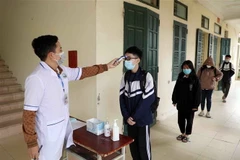 Đo thân nhiệt cho học sinh. (Nguồn: TTXVN)