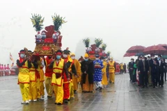 Tám bình nước lấy từ hồ Tam Chúc được buộc chặt nơ đỏ đặt lên kiệu do 8 thanh niên khiêng ngược lên các con dốc dựng đứng và hàng trăm bậc thang đặt vào các địa điểm: Tam Quan Nội, Điện Quán Âm, Điện Giáo Chủ, Điện Tam Thế, Chùa Ngọc. (Ảnh: Đại Nghĩa/TTXV