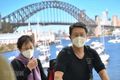 Hành khách đeo khẩu trang phòng lây nhiễm COVID-19 tại sân bay ở Sydney, Australia. (Ảnh: AFP/TTXVN)