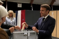 Tổng thống Pháp Emmanuel Macron (phải) bỏ phiếu bầu cử Quốc hội vòng hai tại Le Touquet ngày 19/6. (Ảnh: AFP/TTXVN)