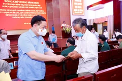 Chủ tịch Quốc hội Vương Đình Huệ tặng quà tặng quà gia đình chính sách, hộ nghèo. (Ảnh: Doãn Tấn/TTXVN)