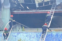 Các chiến sỹ dùng thang tiếp cận hiện trường vụ cháy ngày 3/7. (Ảnh: Tường Quân/TTXVN)