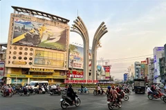Người dân tham gia giao thông tại vòng xoay Đèn 4 Ngọn, đường Trần Hưng Đạo, thành phố Long Xuyên, An Giang khi thành phố trở thành vùng xanh. (Ảnh: Thanh Sang/TTXVN)