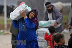 Người tị nạn Syria nhận hàng viện trợ. (Ảnh: AFP/TTXVN)