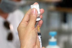 Lấy vaccine trước khi tiêm phòng COVID-19. (Nguồn: TTXVN)