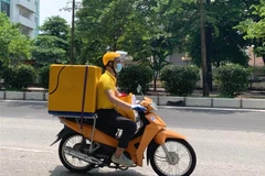 Nhân viên bưu chính vận chuyển hàng hóa. (Ảnh minh họa. Nguồn: TTXVN)