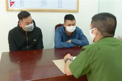 Hai đối tượng Nguyễn Anh Tuấn (trái) và Lê Văn (phải) tại cơ quan điều tra. (Ảnh: TTXVN phát)