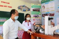 Em Vi Thị Thu Hà giới thiệu máy hút dịch chanh dây bán tự động. Ảnh: Tuấn Anh/TTXVN)