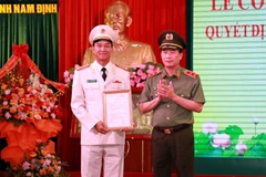 Trung tướng Lê Quốc Hùng, Thứ trưởng Bộ Công an trao quyết định của Bộ trưởng Công an về việc điều động, bổ nhiệm Đại tá Trần Minh Tiến giữ chức Giám đốc Công an tỉnh Nam Định. (Ảnh: Văn Đạt/TTXVN)