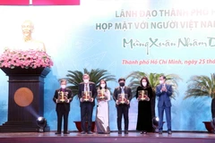 Đại sứ Lương Thanh Nghị, Phó Chủ nhiệm Ủy ban về người Việt Nam ở nước ngoài, Bộ Ngoại giao thừa ủy quyền của Chủ tịch nước trao quà cho 5 đại biểu người Việt Nam ở nước ngoài tiêu biểu. (Ảnh: Xuân Khu/TTXVN)