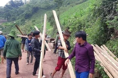 Lực lượng đoàn viên thanh niên Huyện đoàn Nậm Pồ tham gia tháo dỡ, vận chuyển nhà ở, tài sản cho các hộ dân nằm dưới cung trượt sạt ở bản Huổi Đắp (xã Nậm Tin, huyện Nậm Pồ, tỉnh Điện Biên). (Ảnh: TTXVN phát)