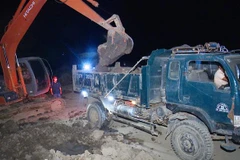 Các đối tượng thực hiện hành vi khai thác đất trái phép tại bãi đất trên địa bàn ấp 1, xã Tân Phong, thị xã Giá Rai. (Ảnh: TTXVN phát)