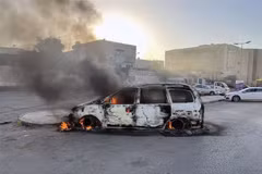 Ôtô bị đốt cháy trong các vụ đụng độ tại Tripoli, Libya, ngày 27/8. (Ảnh: THX/TTXVN)